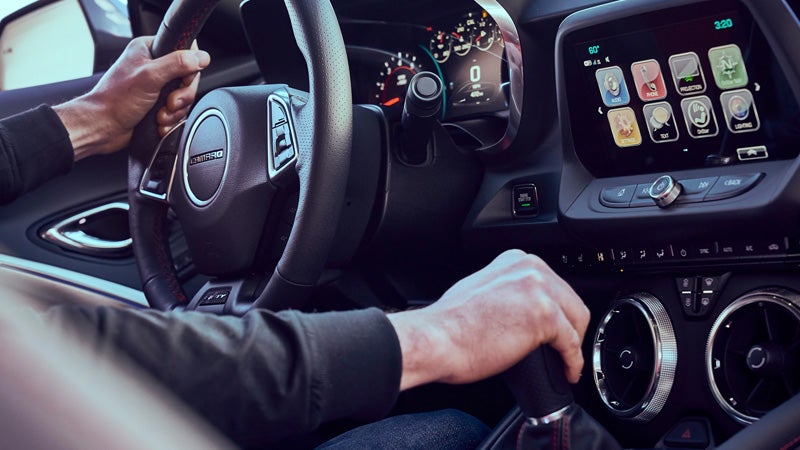 Driver hands on Chevrolet Camaro steering wheel and shifter