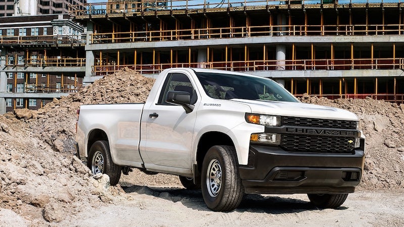 White Chevrolet Silverado pickup truck at a construction site.