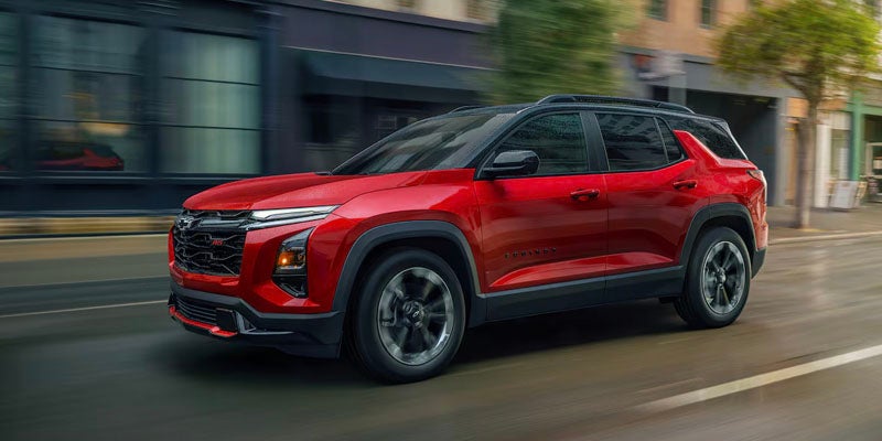 Red Chevrolet Equinox EV electric SUV driving on a city street