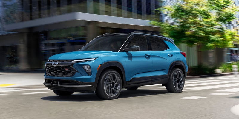 Blue Chevy Trailblazer RS SUV driving on a city street with a blurred background.