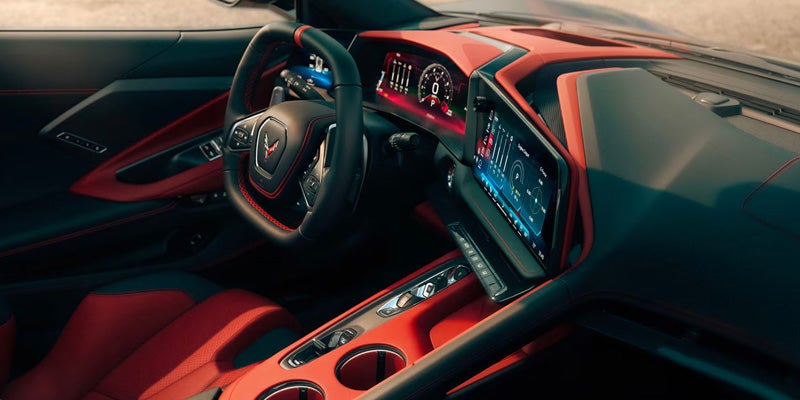 Modern sports car interior featuring red leather seats, a digital display, and a performance-focused cockpit design