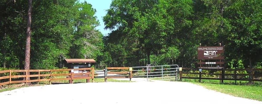 Wooden entrance gate and sign at park trail
